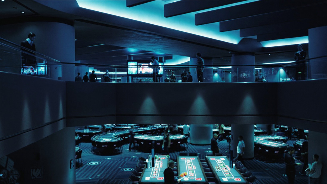 Wide view across a busy casino room of gaming tables and guests